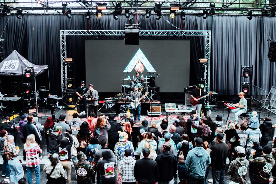 Full band playing to a packed crowd at an outdoor stage