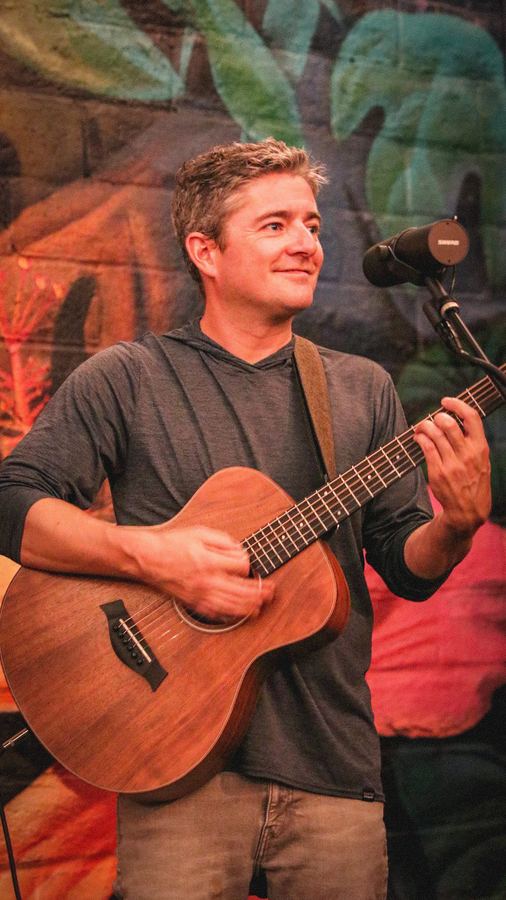 Musician playing an acoustic guitar outdoors