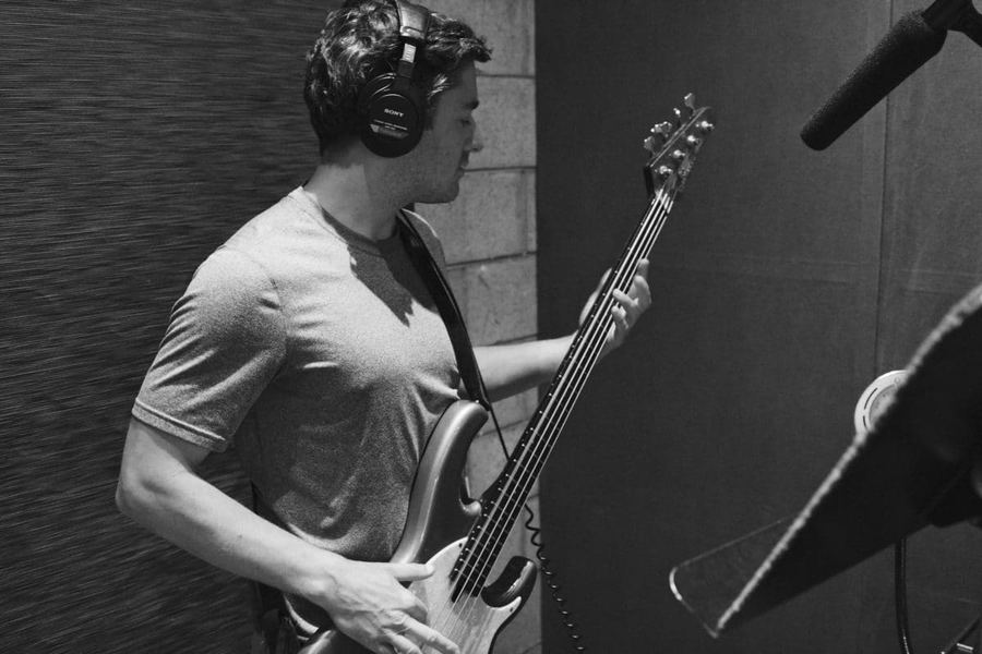 Black and white studio photograph of a musician at a microphone