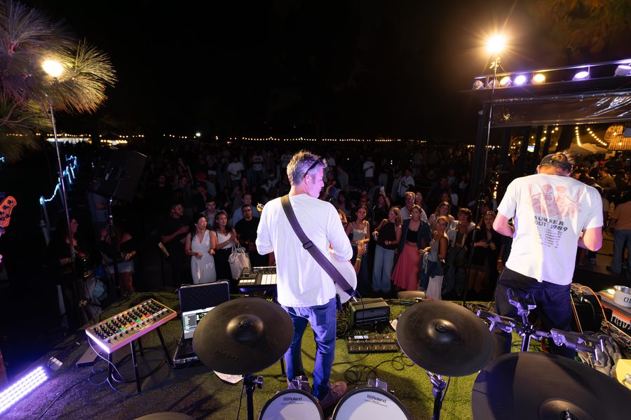 View from behind the drum kit across the stage to a full crowd