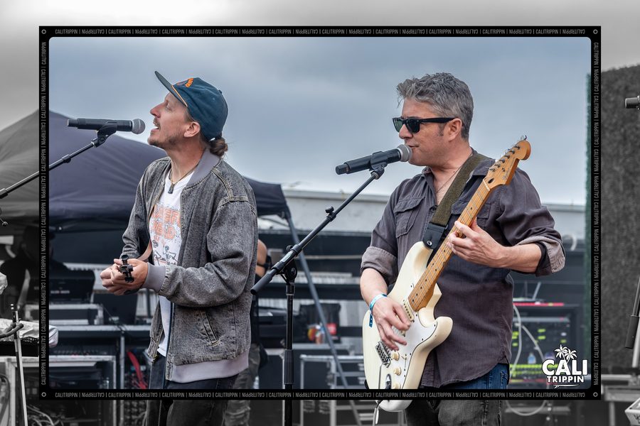 Bassist and vocalist side by side on an outdoor stage