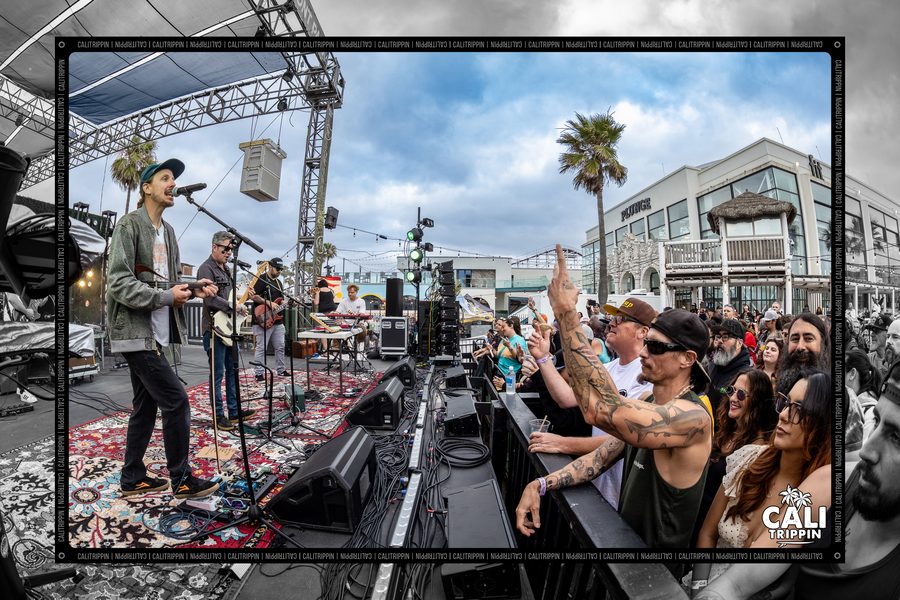 Crowd with arms raised in front of the outdoor stage
